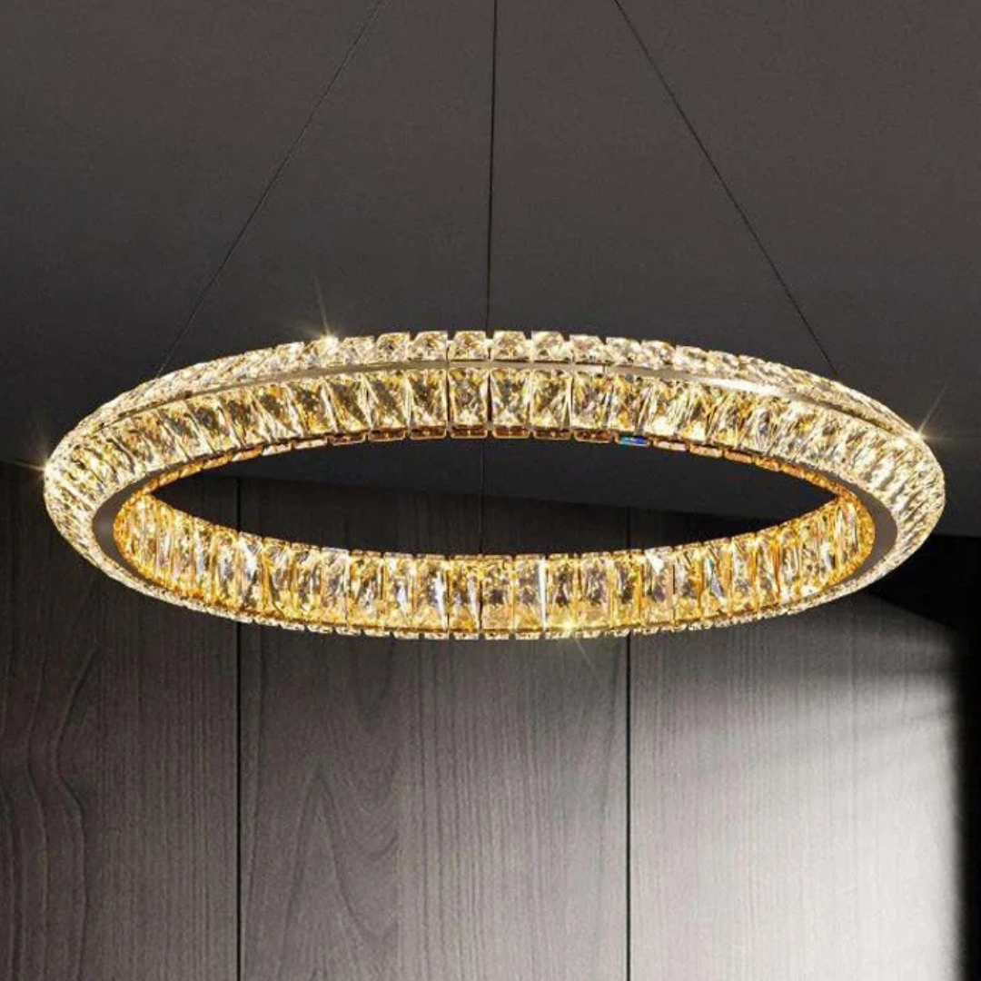 Gold circular chandelier against a dark background