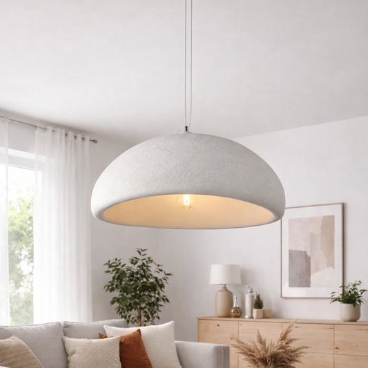 Modern pendant light hanging in a living room with decor elements.