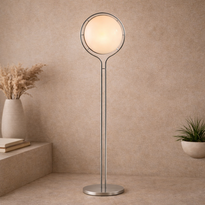 Modern floor lamp with a round glass shade in a room with beige walls and decorative plants.