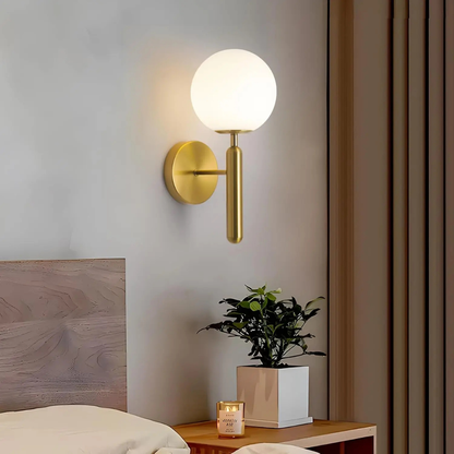 Modern wall sconce with a spherical light fixture on a neutral wall.