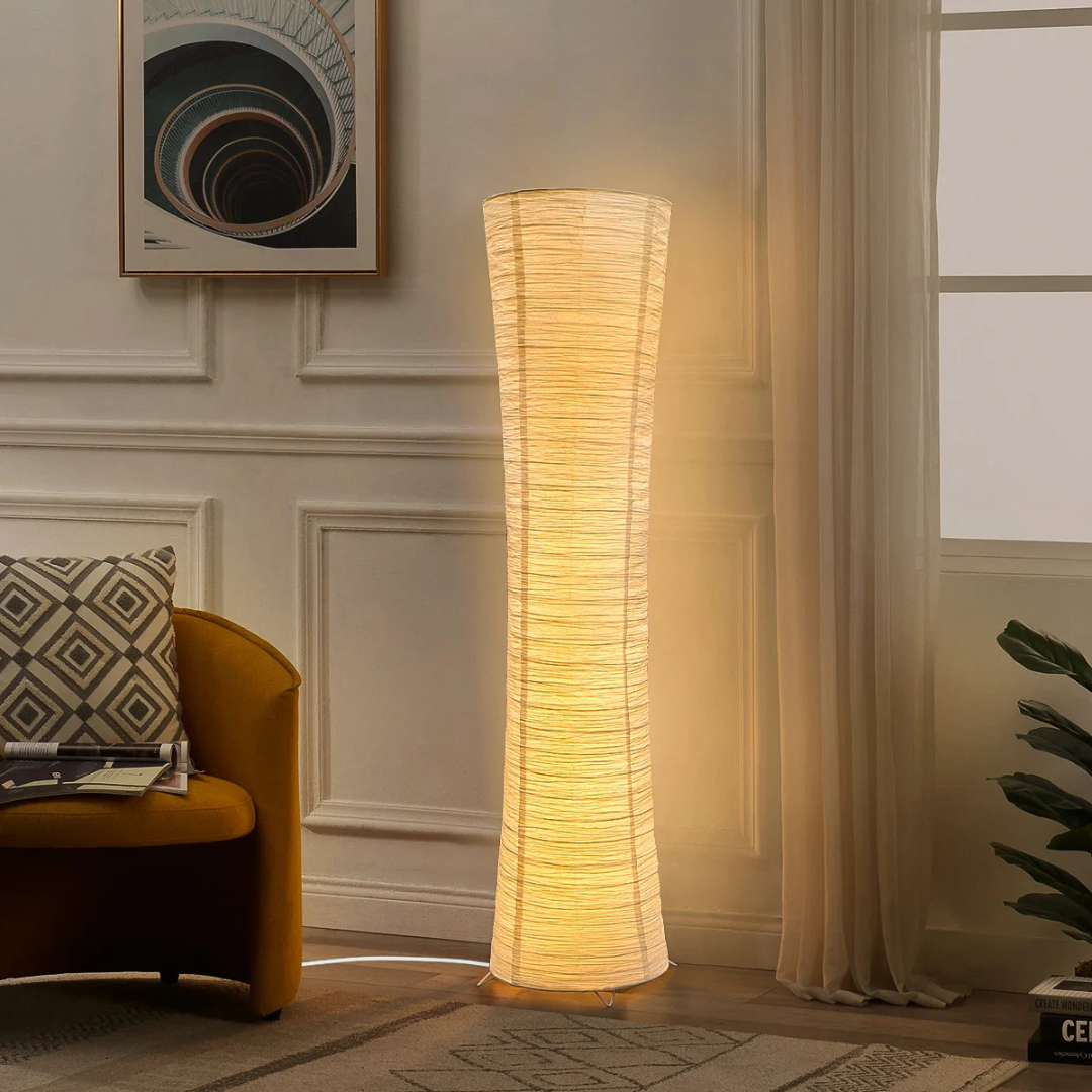 Floor lamp in a living room with a couch and decorative elements.
