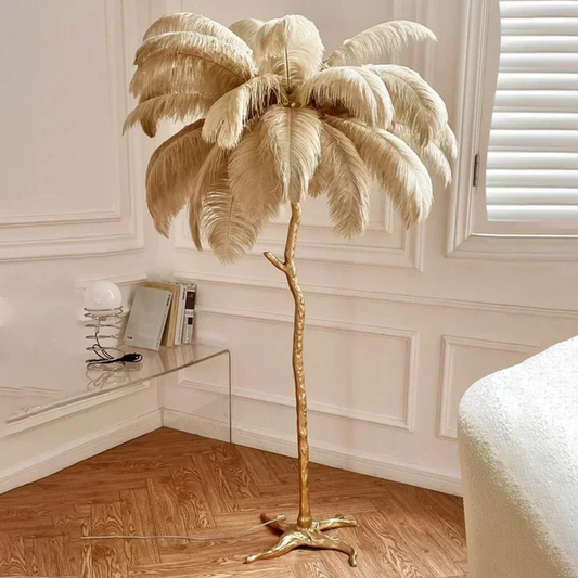 Gold palm tree floor lamp in a room with wooden flooring and white walls.