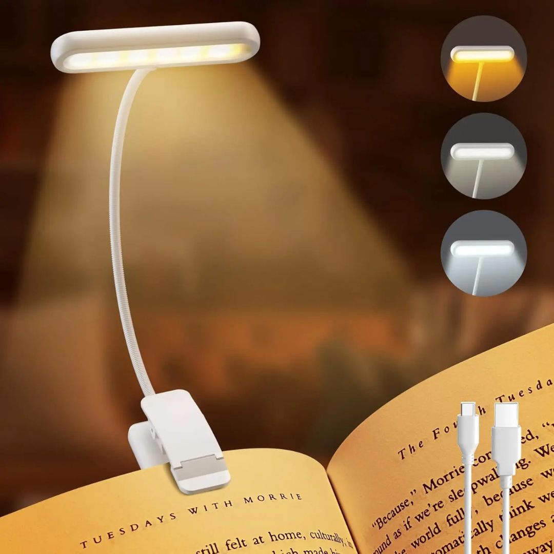 Clip-on reading lamp with flexible arm on an open book, showing three light settings.