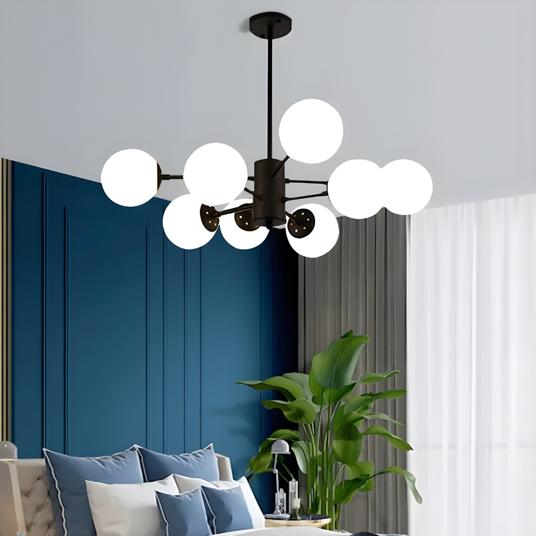 Modern chandelier in a living room with blue walls and decorative pillows.