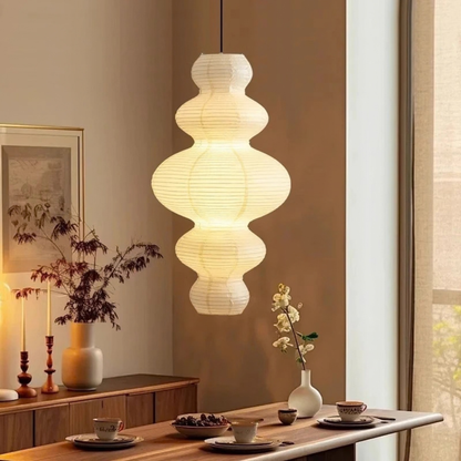 Pendant light fixture hanging above a dining table with decor items.