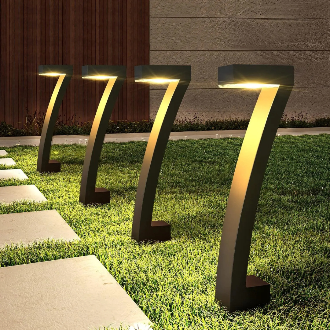 Modern outdoor garden lights on grass with a building in the background