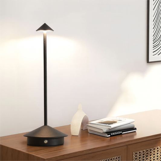 Modern black table lamp on a wooden surface with a minimalistic background