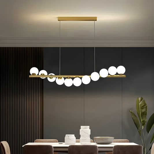 Modern pendant light fixture in a dining room setting with a neutral color palette.