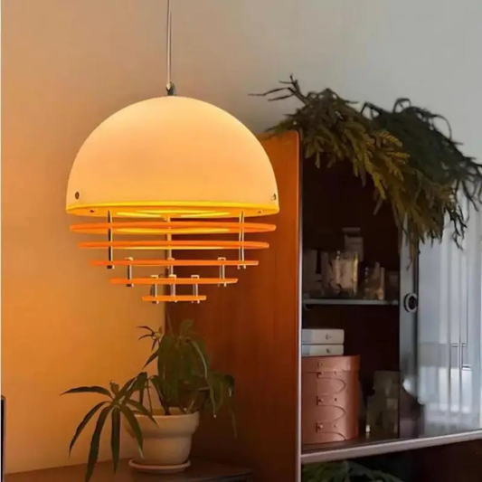 Yellow pendant light hanging in a room with plants and shelves.
