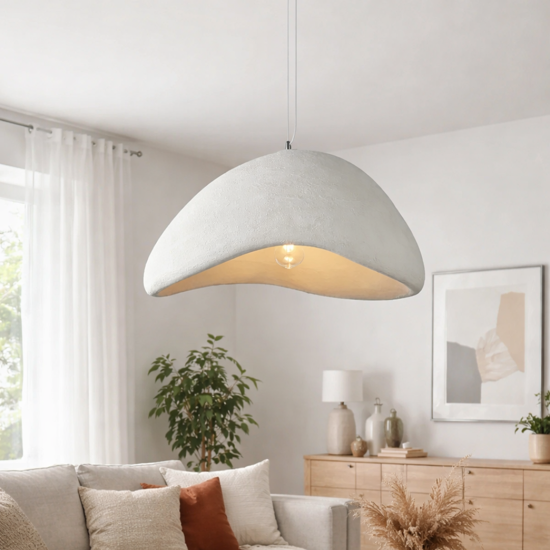 Modern pendant light hanging in a living room with decor elements.